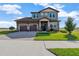 Charming two-story home with a three-car garage, manicured lawn and a beautiful brick driveway on a sunny day at 200 Valencia Ridge Dr, Auburndale, FL 33823