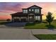 Charming two-story home with a three-car garage, manicured lawn and a beautiful brick driveway at sunset at 200 Valencia Ridge Dr, Auburndale, FL 33823