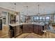 Open concept kitchen with wood floors, stainless steel appliances, and island seating adjacent to the dining and living areas at 200 Valencia Ridge Dr, Auburndale, FL 33823