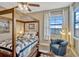 Charming main bedroom features a four poster bed, accent chair and water views at 200 Valencia Ridge Dr, Auburndale, FL 33823