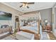 Comfortable bedroom with canopy bed, modern ceiling fan and adjacent en-suite bathroom at 200 Valencia Ridge Dr, Auburndale, FL 33823