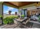 Beautiful covered patio with a dining table, outdoor lighting, and lush greenery, ideal for enjoying meals outdoors at 200 Valencia Ridge Dr, Auburndale, FL 33823
