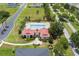 Aerial view of the community clubhouse with a pool, red roof, lush landscaping, and sidewalk access at 200 Valencia Ridge Dr, Auburndale, FL 33823