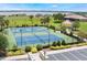 Aerial view of blue and green sports courts including tennis and basketball, landscaped with mature trees and view of the lake at 200 Valencia Ridge Dr, Auburndale, FL 33823