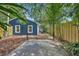 A patio and walkway lead to a blue home with bamboo plants and a wooden fence at 2004 E Marks St, Orlando, FL 32803