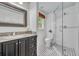 Updated bathroom featuring a glass walk-in shower, granite countertop, and a monochrome floor at 2004 E Marks St, Orlando, FL 32803