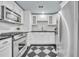 Bright kitchen featuring stainless steel appliances, white cabinetry, and a unique checkered floor at 2004 E Marks St, Orlando, FL 32803