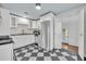 Modern kitchen with white cabinets, stainless steel appliances, and a stylish black and white checkered floor at 2004 E Marks St, Orlando, FL 32803
