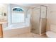 Spacious bathroom features a large soaking tub with glass block window and tiled shower at 2025 Claremont Dr, Deltona, FL 32725