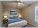 A simple bedroom features a queen bed with blue accents, ceiling fan, and two side tables at 2025 Claremont Dr, Deltona, FL 32725