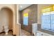 Modern bathroom with tub, shower, and neutral tile, complemented by yellow window accents at 20951 County Road 561, Clermont, FL 34715