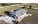 The rear exterior featuring a tile roof, large garage, a turfed backyard space and stone landscaping at 20951 County Road 561, Clermont, FL 34715