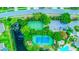 An aerial view displays community recreational facilities: tennis and basketball courts near a lake at 2626 Greenwillow Dr, Orlando, FL 32825