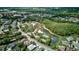 Scenic aerial view of community amenities, including a pool, tennis courts, and a pond with lush landscaping at 2626 Greenwillow Dr, Orlando, FL 32825
