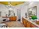 Spacious bathroom with dual sinks, wooden cabinets, decorative plants, and a chandelier at 2626 Greenwillow Dr, Orlando, FL 32825