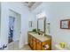 Well-lit bathroom featuring a wood-framed mirror, decorative lighting, and neutral-toned countertop and cabinetry at 2626 Greenwillow Dr, Orlando, FL 32825