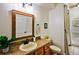Bathroom with wood vanity, framed mirror, toilet, tiled floor, and a shower with a curtain at 2626 Greenwillow Dr, Orlando, FL 32825