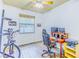 Bright bedroom with a ceiling fan, wood-look floors, a bicycle, and a workstation with multiple monitors at 2626 Greenwillow Dr, Orlando, FL 32825