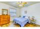 Cozy bedroom with hardwood floors, ceiling fan, dresser, and large window offering natural light at 2626 Greenwillow Dr, Orlando, FL 32825