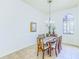 Formal dining area features decorative chandelier, six chairs, and lots of natural light from the large arched window at 2626 Greenwillow Dr, Orlando, FL 32825