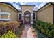 Inviting front entrance featuring beautiful glass double doors, stone accents, and mature landscaping at 2626 Greenwillow Dr, Orlando, FL 32825