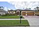 Charming single Gathering home featuring a well-manicured lawn, 3-car garage, and elegant exterior finishes at 2626 Greenwillow Dr, Orlando, FL 32825