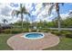 Community hot tub with surrounding brick patio, chairs, and lush landscaping at 2626 Greenwillow Dr, Orlando, FL 32825