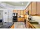 Well-equipped kitchen with wood cabinets, black countertops, and stainless steel appliances at 2626 Greenwillow Dr, Orlando, FL 32825