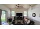 Spacious living room featuring tile floors, fan, windows, and comfortable leather seating at 2626 Greenwillow Dr, Orlando, FL 32825