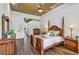 Spacious main bedroom features a tray ceiling with ceiling fan, wood floors, and stylish furniture at 2626 Greenwillow Dr, Orlando, FL 32825