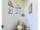 Well-lit powder room featuring charming arched windows, neutral colors, and space-saving design at 2626 Greenwillow Dr, Orlando, FL 32825