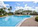 Large community pool with ample seating, palm trees, and clear blue water at 2626 Greenwillow Dr, Orlando, FL 32825