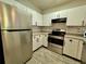 Well-lit kitchen featuring stainless steel appliances, white cabinets, and wood-look floors at 304 E South St # 1023, Orlando, FL 32801