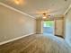 Bright living room featuring wood-look floors, ceiling fan, and a balcony with natural light at 304 E South St # 1023, Orlando, FL 32801