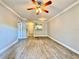 A bright, open-concept living room featuring wood-look tile floors and modern ceiling fan at 304 E South St # 1023, Orlando, FL 32801