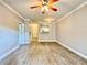 A bright, open-concept living room featuring wood-look tile floors and modern ceiling fan at 304 E South St # 1023, Orlando, FL 32801