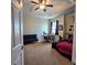 Bedroom features ceiling fan and tray ceiling with a desk and futon at 3301 Bethpage Loop, Mount Dora, FL 32757