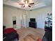 Bedroom with ceiling fan and tray ceiling with a television and futon at 3301 Bethpage Loop, Mount Dora, FL 32757