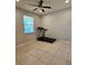 Neutral bedroom featuring tile floors, a window, and fitness equipment at 3301 Bethpage Loop, Mount Dora, FL 32757