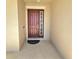 Covered entryway with dark wood front door, side light, and concrete floor at 3301 Bethpage Loop, Mount Dora, FL 32757