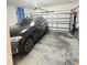 Spacious garage with storage and a sleek black SUV parked inside at 3301 Bethpage Loop, Mount Dora, FL 32757