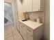 Clean laundry room featuring white cabinets, a light countertop, and a stainless steel faucet at 3301 Bethpage Loop, Mount Dora, FL 32757