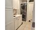 Bright laundry room features stacked washer and dryer, white cabinets, and a light countertop at 3301 Bethpage Loop, Mount Dora, FL 32757