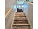 Modern wooden staircase with a white handrail leading to the upper level of the home at 3301 Bethpage Loop, Mount Dora, FL 32757
