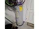 Gray water heater with energy guide is installed near a white textured cinderblock wall and a white door at 3301 Bethpage Loop, Mount Dora, FL 32757