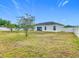 Wide backyard view with bright green grass, tall privacy fence, and rear home elevation at 332 Blue Lake Cir, Kissimmee, FL 34758