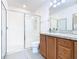 Bright bathroom featuring a walk-in shower with a glass door, vanity with storage and bright lighting at 332 Blue Lake Cir, Kissimmee, FL 34758