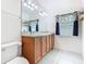 Bathroom featuring double sinks, cabinet storage, a toilet and bright lighting from a window at 332 Blue Lake Cir, Kissimmee, FL 34758