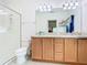 The bright bathroom offers double sinks, cabinet storage, a toilet and glass-enclosed shower at 332 Blue Lake Cir, Kissimmee, FL 34758