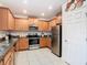 Bright kitchen with stainless steel appliances, granite countertops, and white tiled floors at 332 Blue Lake Cir, Kissimmee, FL 34758